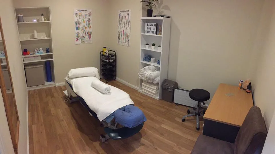 Treatment room at Brunswick Chiropractic — massage table and clinic shelving