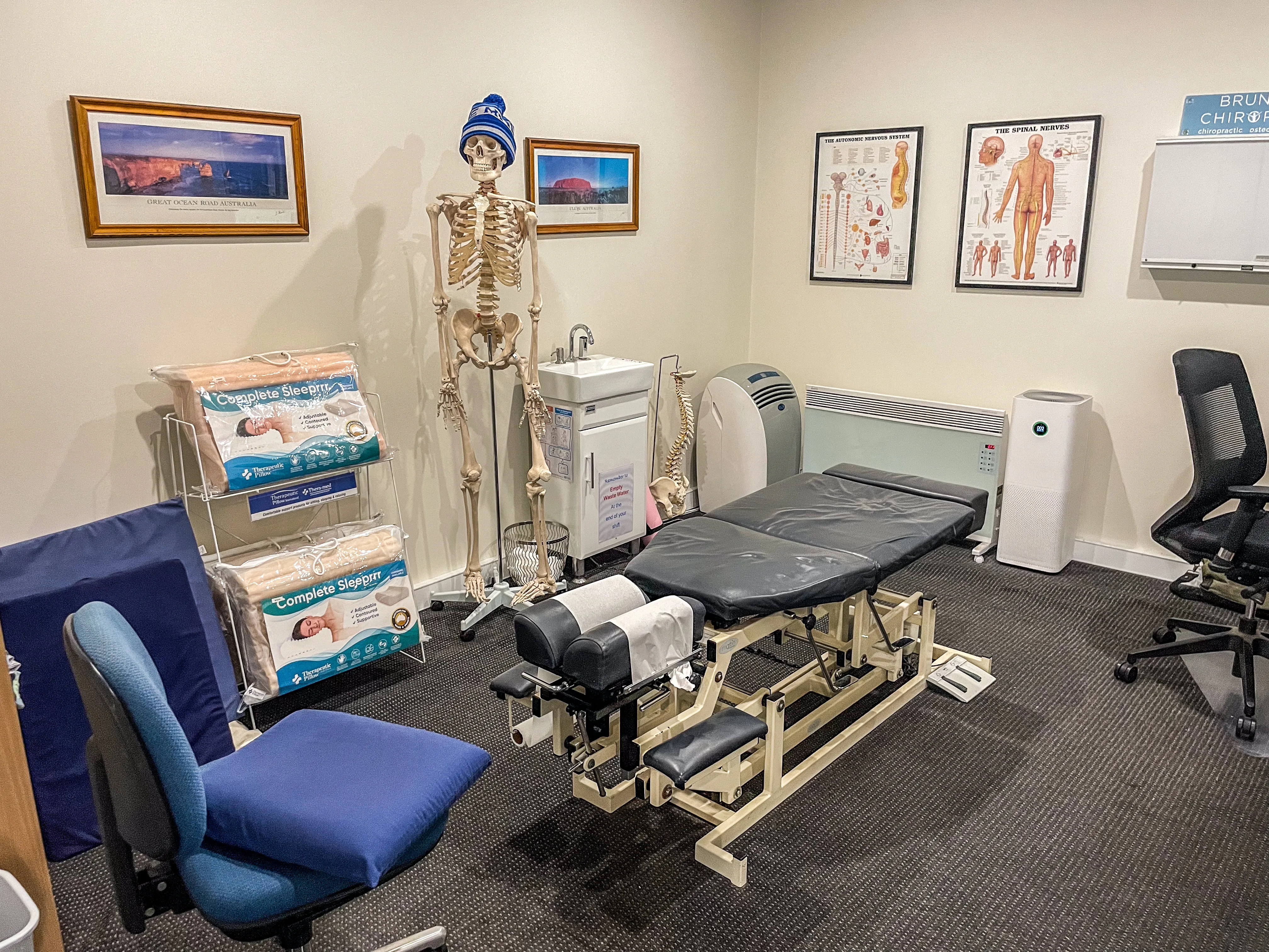 Consulting room with treatment table, skeleton model and anatomy charts