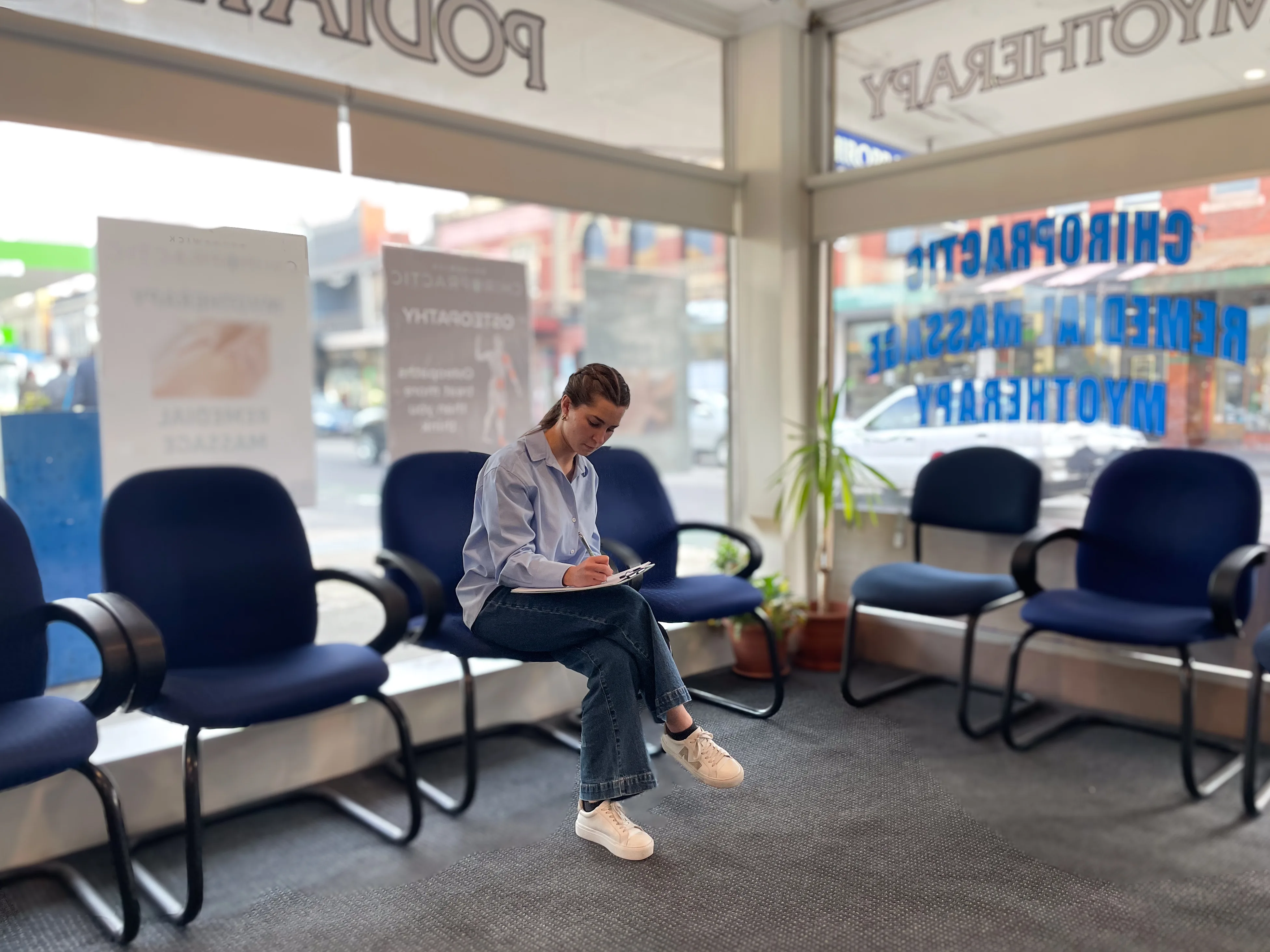 Waiting room at Brunswick Chiropractic with large shopfront windows and patients