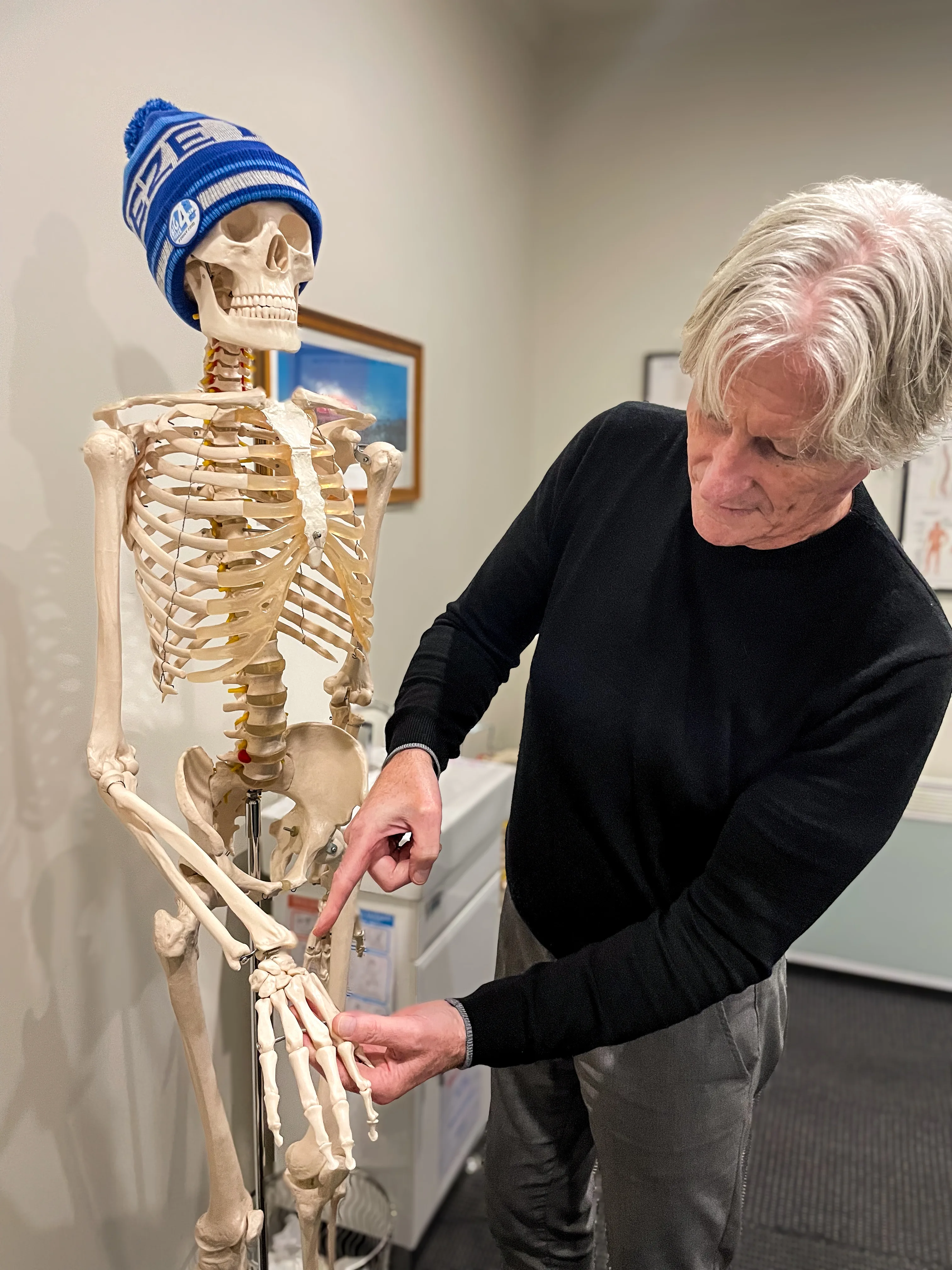 Practitioner demonstrating on a skeleton model during a patient consultation