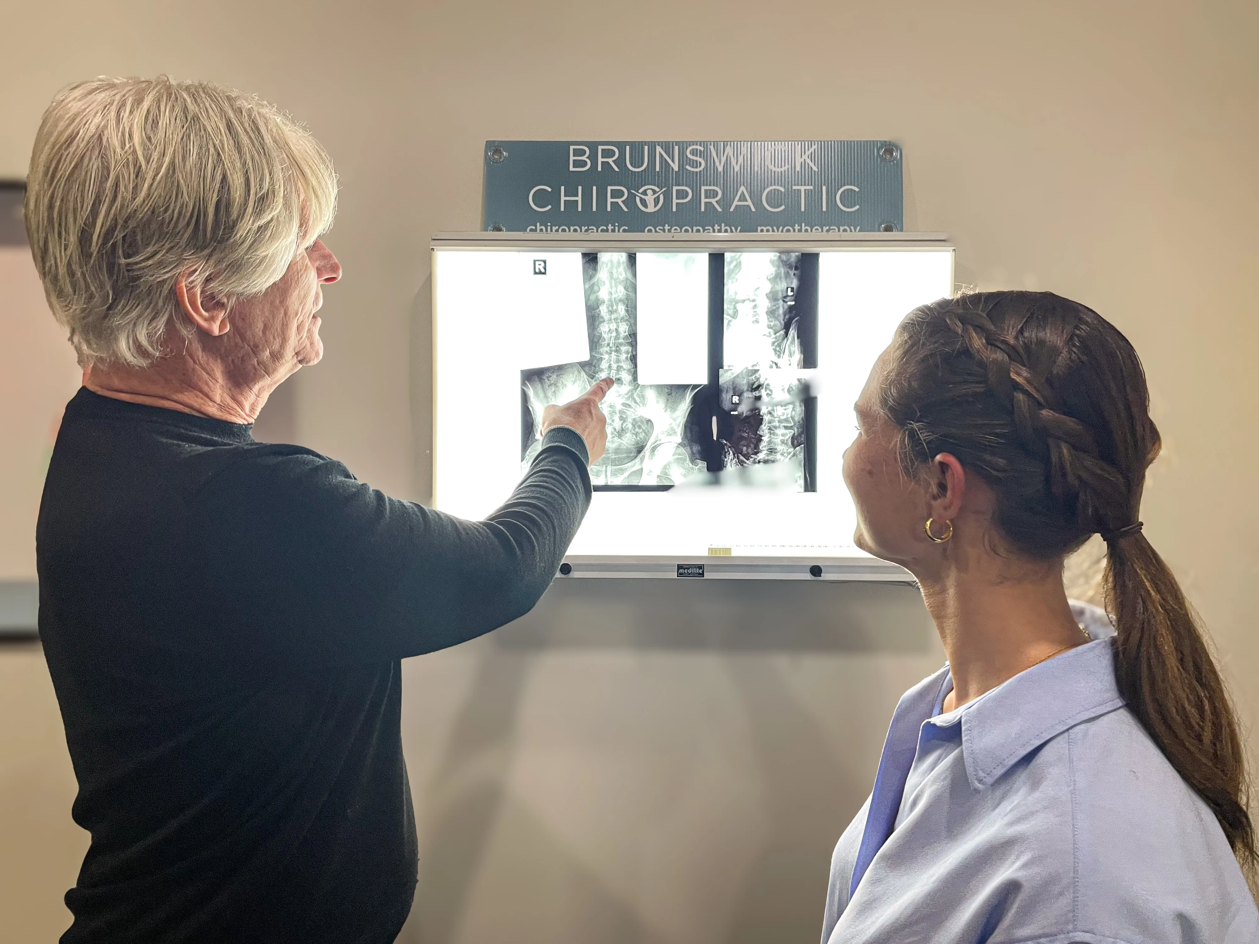 Practitioners reviewing spinal X-rays at the Brunswick Chiropractic lightbox