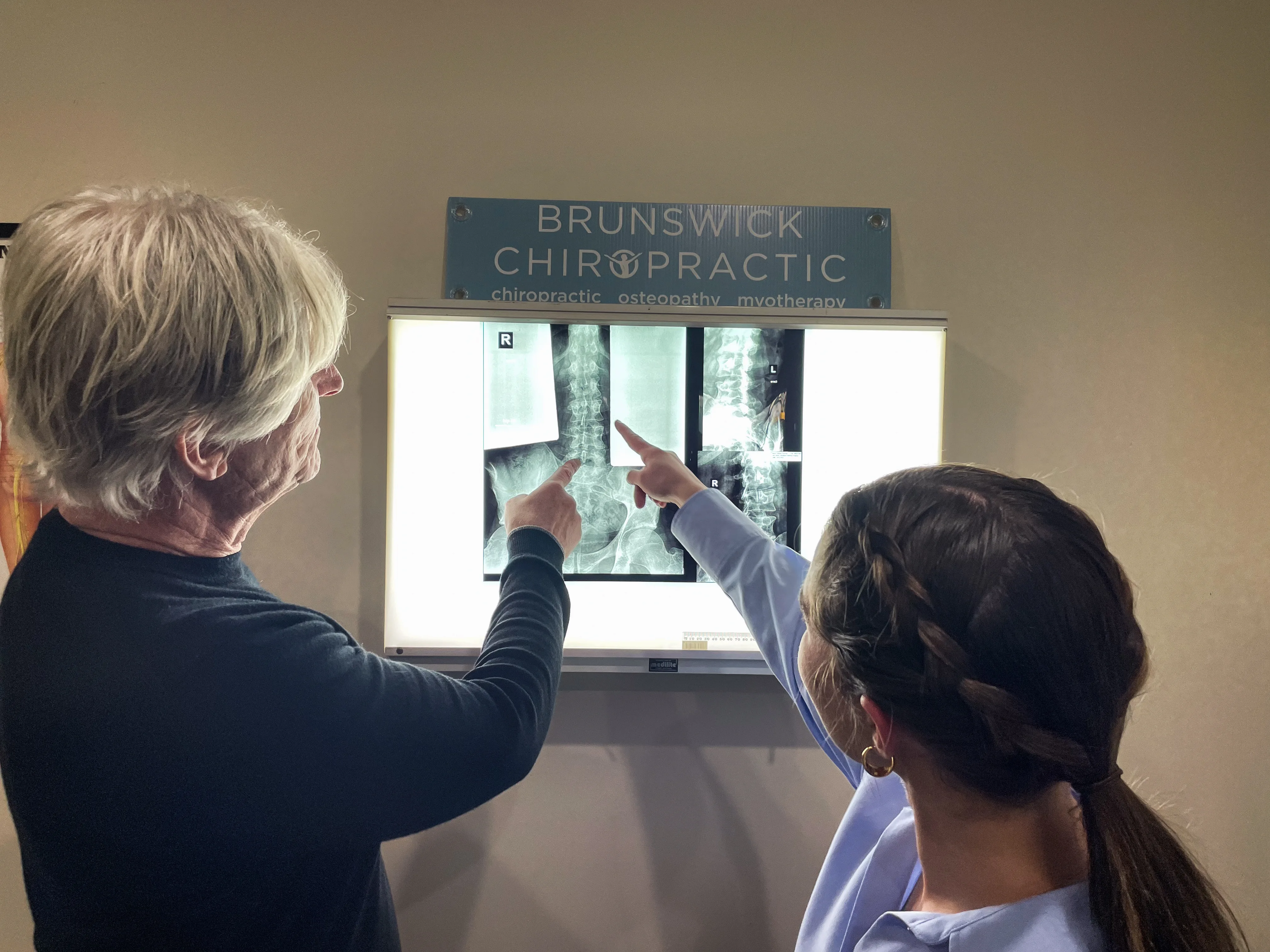 Practitioners reviewing spinal X-rays on the Brunswick Chiropractic lightbox